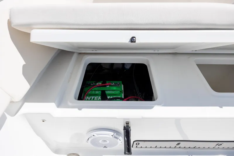 Slide: The Image of 2024 Sea Hunt Ultra 234 boat battery compartment with visible wiring and speaker. - 31