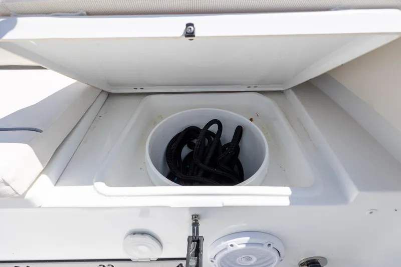 Slide: The Image of Storage compartment on 2024 Sea Hunt Ultra 234 boat with coiled rope inside. - 33