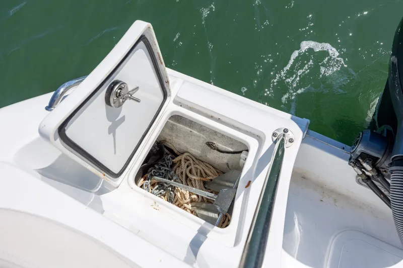Slide: The Image of Open storage compartment on 2024 Sea Hunt Ultra 234 boat with ropes and anchor. - 35