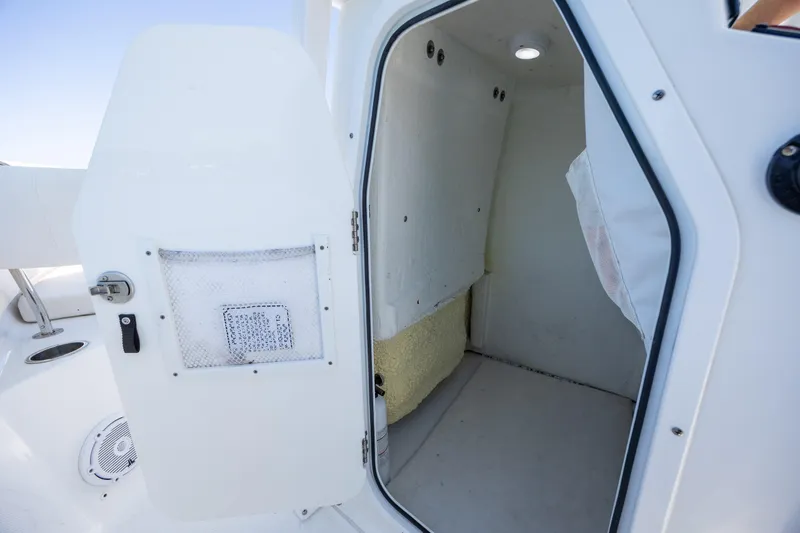 Slide: The Image of 2024 Sea Hunt Ultra 234 boat interior cabin with open door and light. - 37
