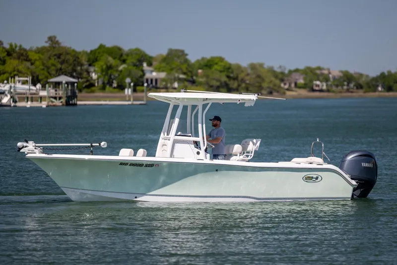 Slide: The Image of 2024 Sea Hunt Ultra 234 boat cruising on a calm lake with a Yamaha engine. - 6