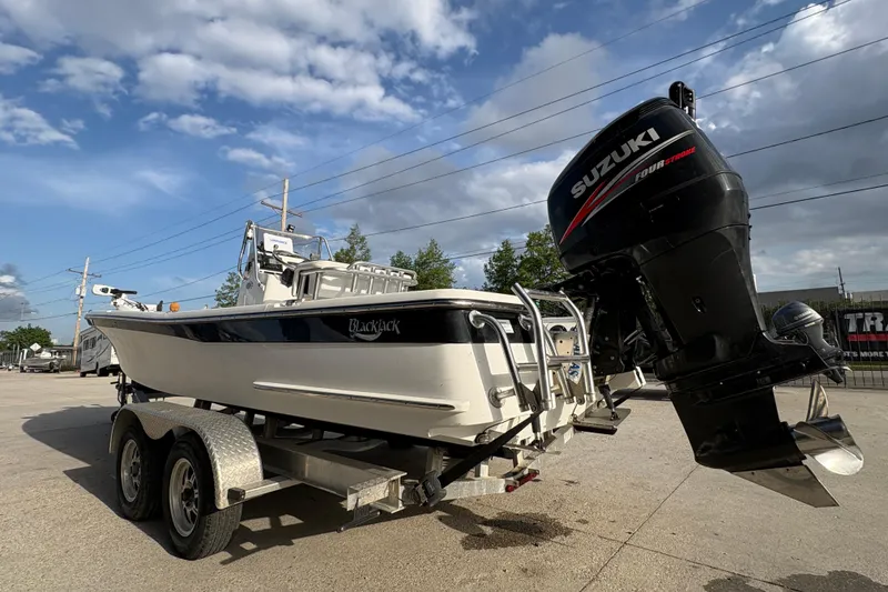 Slide: The Image of 2012 BlackJack 224 boat with Suzuki outboard motor on a trailer under a cloudy sky. - 6