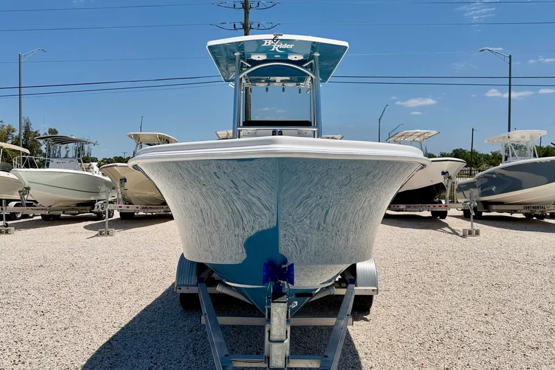 Slide: The Image of 2026 Bay Rider 21 Offshore boat on trailer, displayed in a sunny outdoor showroom. - 2