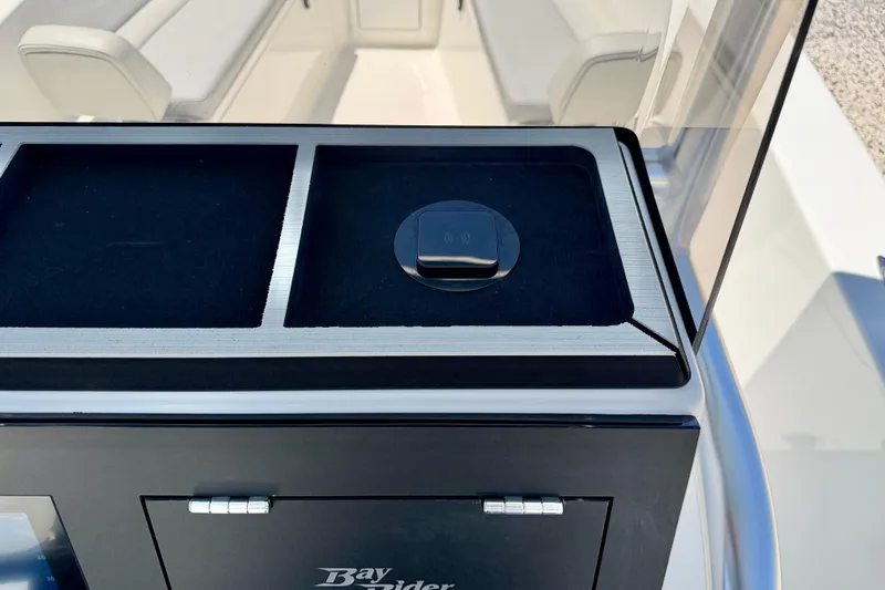 Slide: The Image of 2026 Bay Rider 21 Offshore boat console with wireless charging pad and seating area. - 25