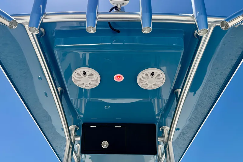 Slide: The Image of Bay Rider 21 Offshore 2026 boat T-top with speakers and blue finish against clear sky. - 39