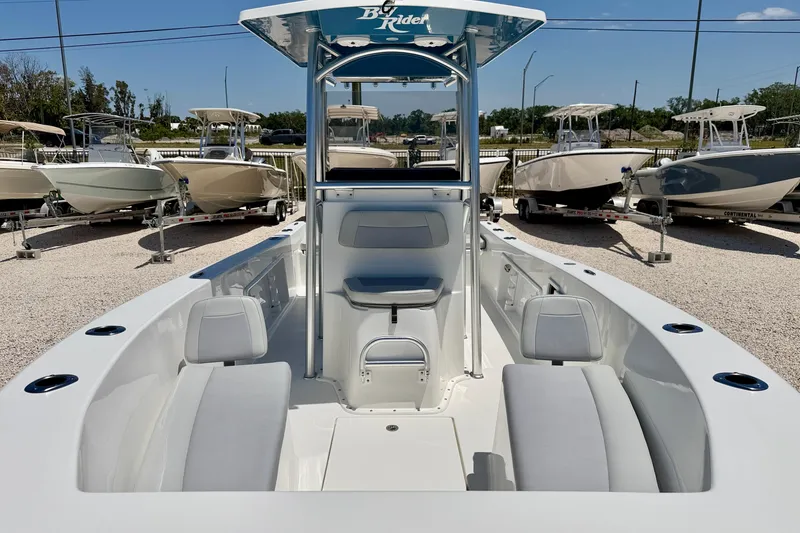 Slide: The Image of 2026 Bay Rider 21 Offshore boat with spacious seating, displayed among other boats in a sunny dealership. - 8