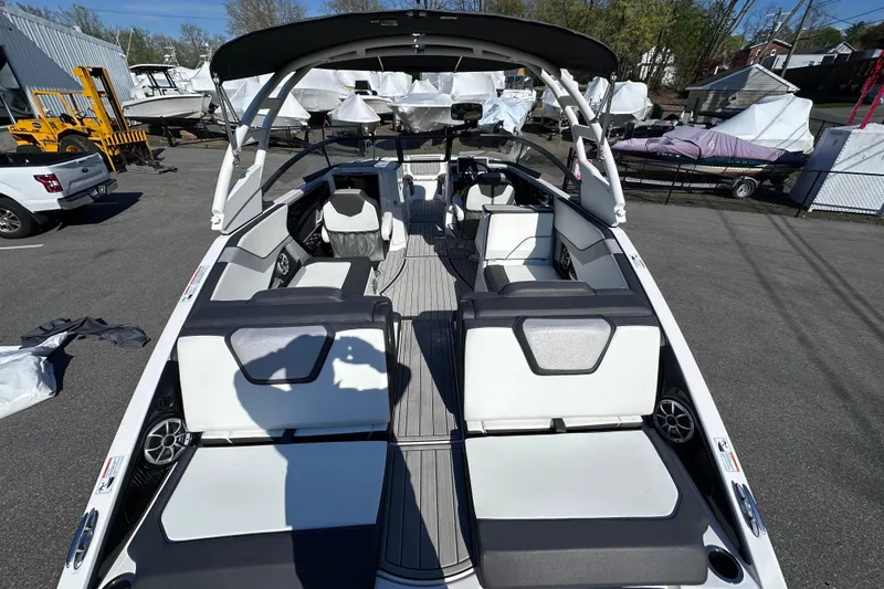 Slide: The Image of 2021 Yamaha Boats 252S interior with sleek seating and modern design in a marina setting. - 10