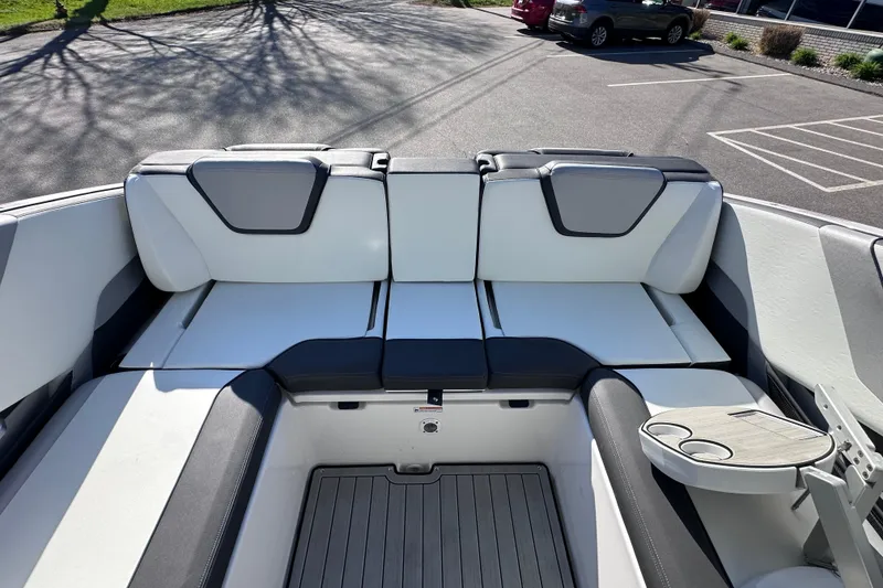 Slide: The Image of 2021 Yamaha Boats 252S interior with white and gray seating, cup holders, and deck flooring. - 18