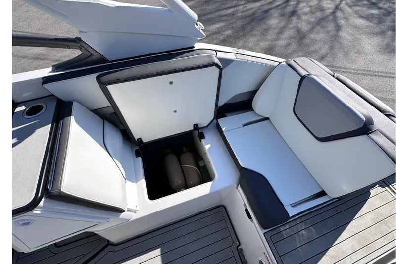 Slide: The Image of 2021 Yamaha Boats 252S interior storage compartment with cushioned seating and open hatch. - 24