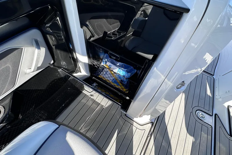 Slide: The Image of 2021 Yamaha Boats 252S interior storage compartment with netting and items inside. - 31