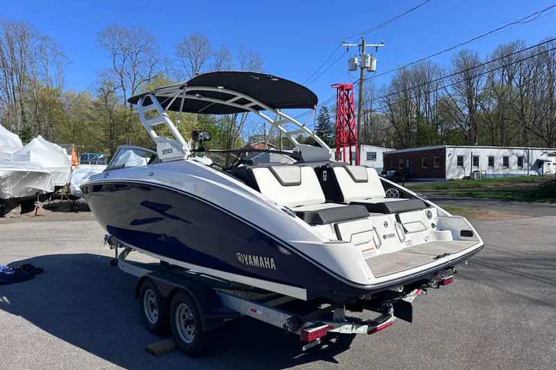 Slide: The Image of 2021 Yamaha Boats 252S on trailer, parked outdoors under clear blue sky. - 5