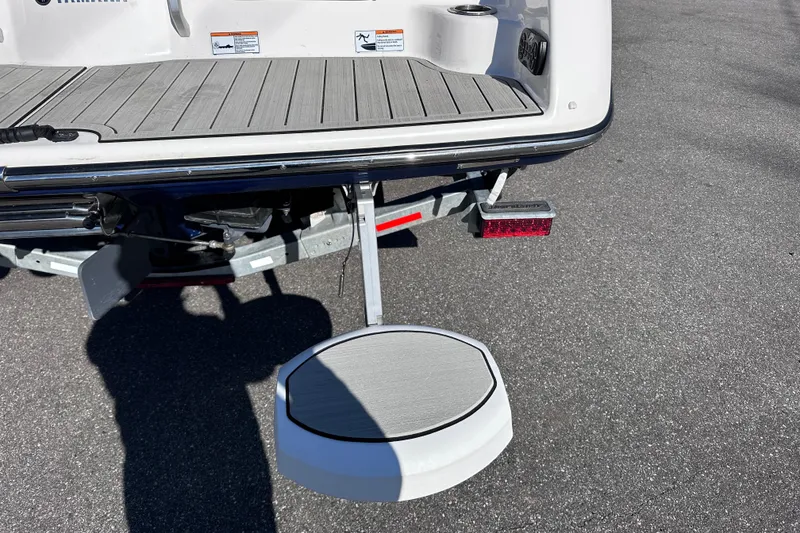 Slide: The Image of 2021 Yamaha Boats 252S swim platform with retractable step on asphalt surface. - 9