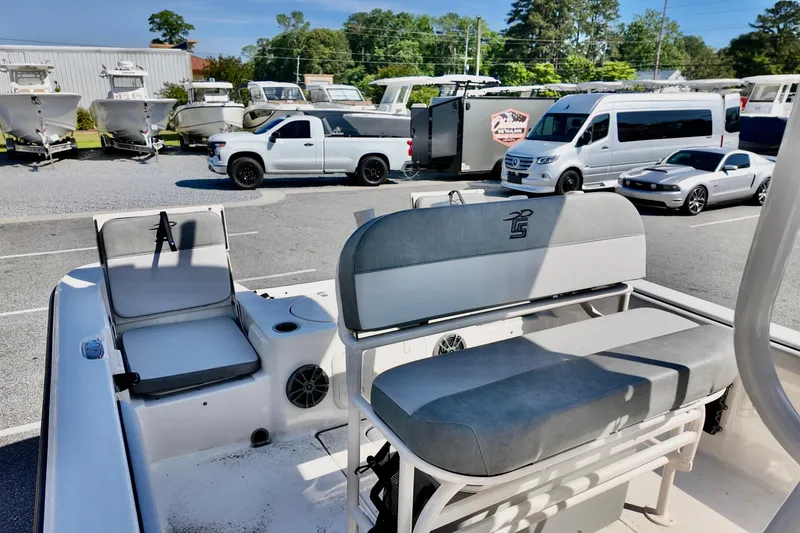 Slide: The Image of 2026 Carolina Skiff 21 LS boat interior with seating, parked vehicles in background. - 9
