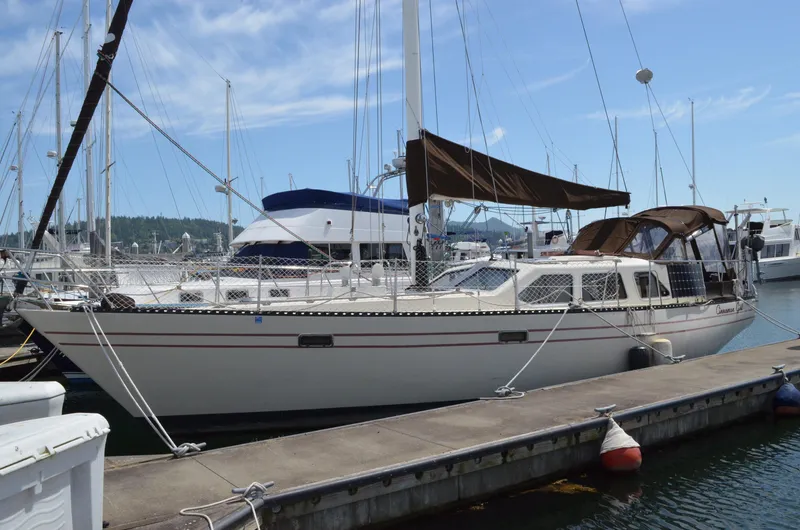 The Image of 1980 Cooper 416 Pilothouse sailboat docked at marina under clear blue sky. - 0