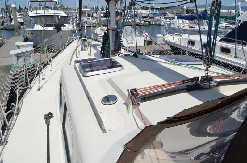 Slide: The Image of 1980 Cooper 416 Pilothouse sailboat docked in a marina, showcasing deck and rigging. - 10
