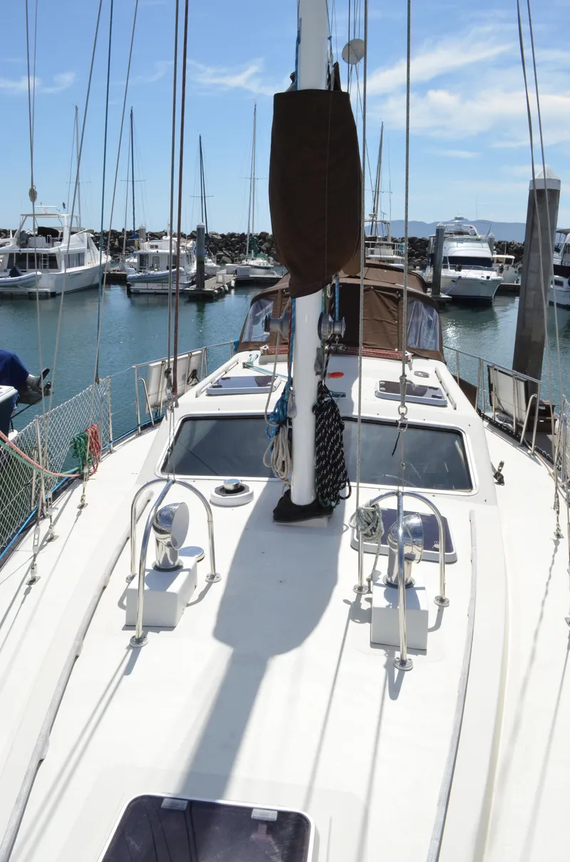 Slide: The Image of 1980 Cooper 416 Pilothouse sailboat docked in a marina under clear skies. - 13