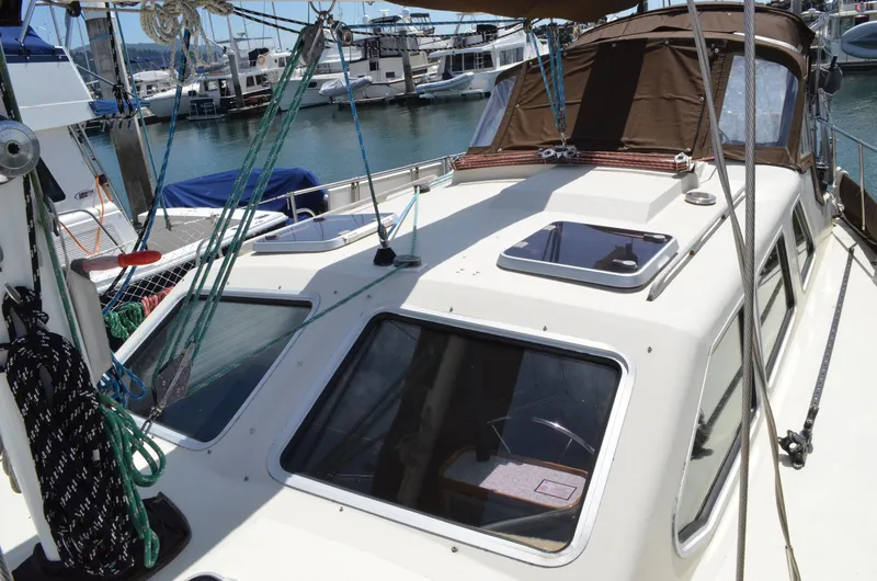 Slide: The Image of 1980 Cooper 416 Pilothouse sailboat docked in a marina, showcasing deck and cabin features. - 14