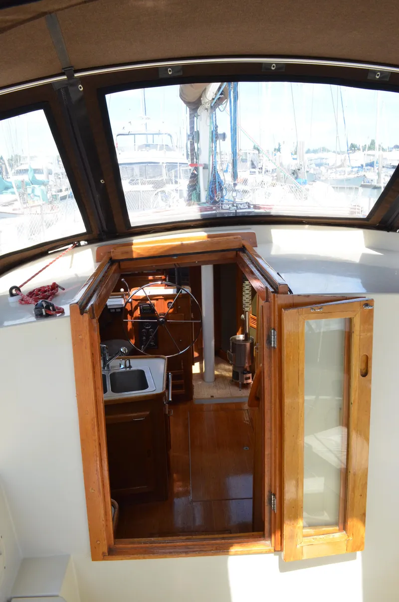 Slide: The Image of 1980 Cooper 416 Pilothouse interior with wooden finish and compact kitchen area. - 22