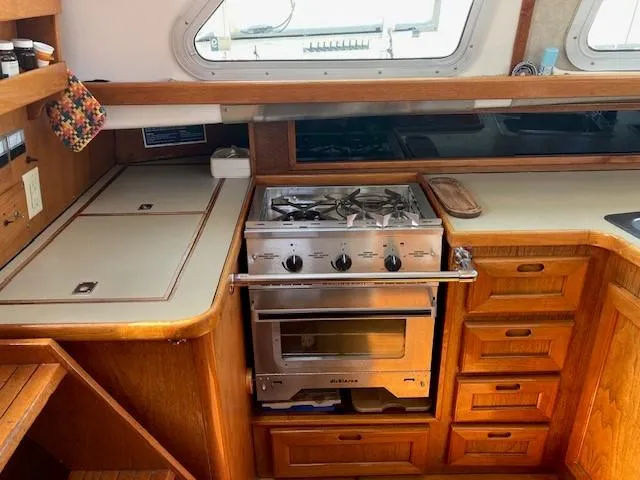 Slide: The Image of 1980 Cooper 416 Pilothouse kitchen with stove, wooden cabinetry, and countertop. - 27