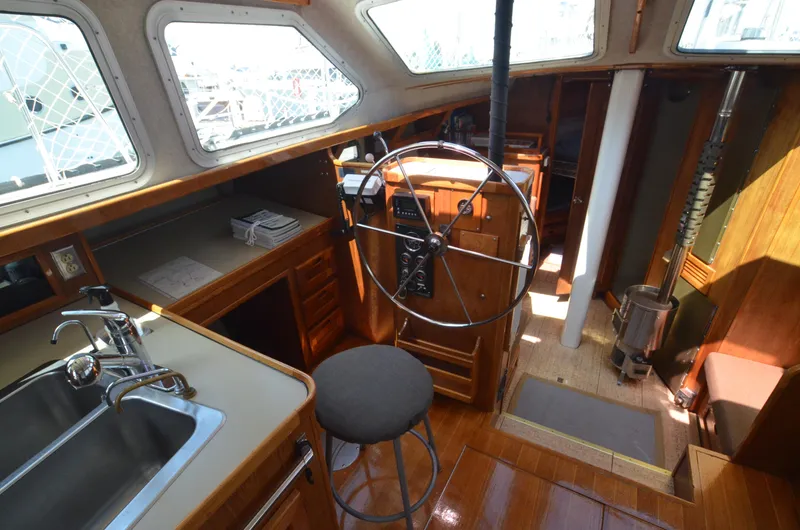 Slide: The Image of 1980 Cooper 416 Pilothouse interior with steering wheel, sink, and wooden cabinetry. - 30