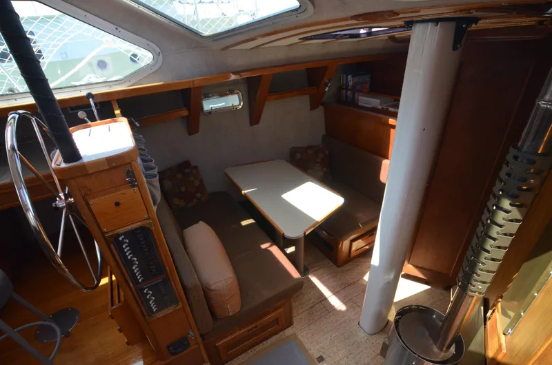 Slide: The Image of Interior of 1980 Cooper 416 Pilothouse with seating and table, showcasing wooden finishes. - 34