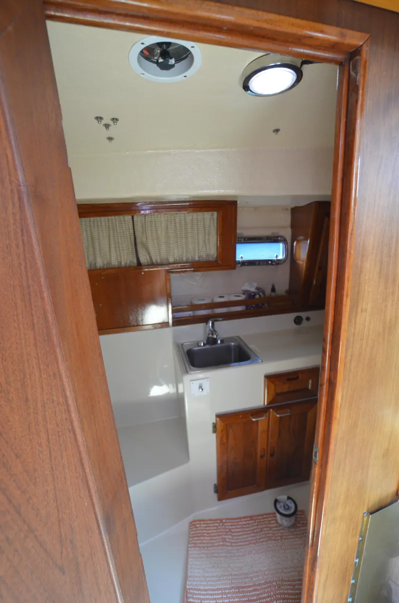 Slide: The Image of 1980 Cooper 416 Pilothouse interior with wooden cabinetry and compact kitchen area. - 39