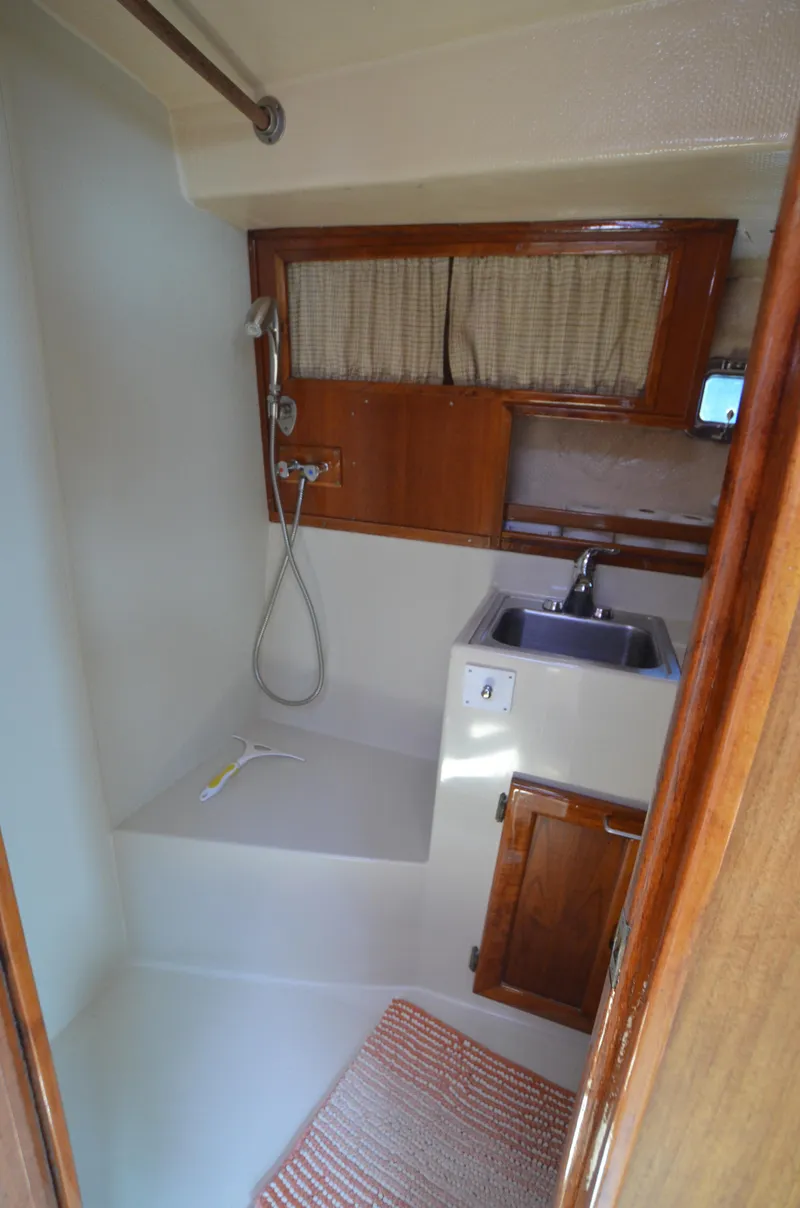 Slide: The Image of 1980 Cooper 416 Pilothouse bathroom with shower, sink, and wooden cabinetry. - 40