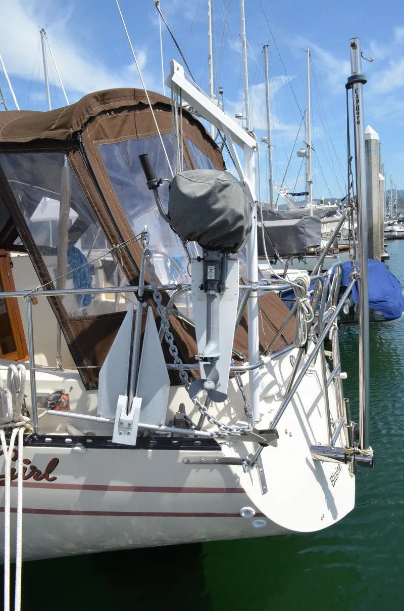 Slide: The Image of 1980 Cooper 416 Pilothouse sailboat docked, featuring a covered outboard motor and brown canopy. - 7