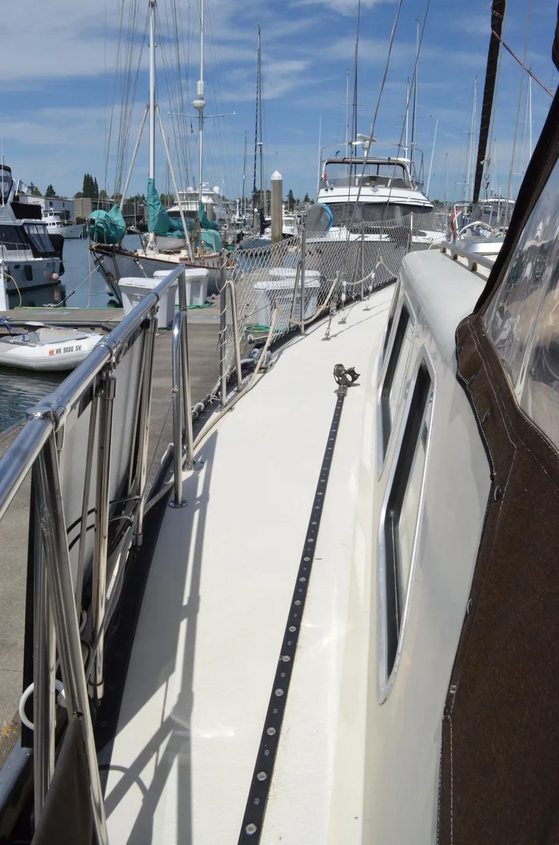 Slide: The Image of 1980 Cooper 416 Pilothouse yacht docked at a marina, surrounded by other boats. - 9