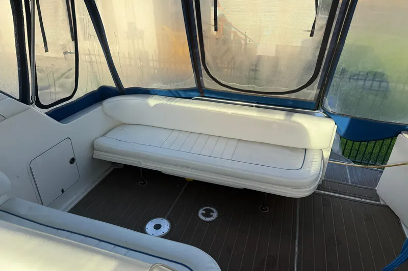 Slide: The Image of 1996 Sea Ray Sundancer 330 interior with white seating and enclosed canopy. - 12