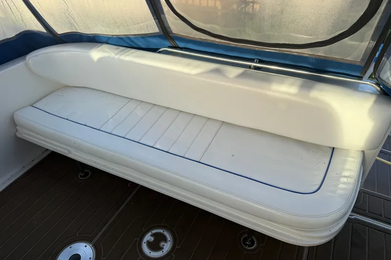 Slide: The Image of 1996 Sea Ray Sundancer 330 interior with white cushioned seating and blue trim. - 15