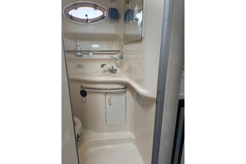 Slide: The Image of 1996 Sea Ray Sundancer 330 bathroom with sink, mirror, and porthole window. - 16