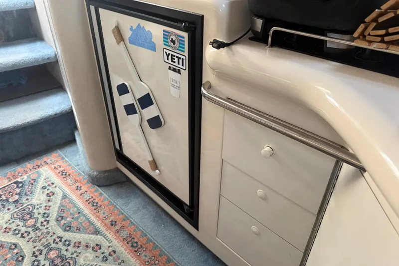 Slide: The Image of Interior of a 1996 Sea Ray Sundancer 330 with fridge, drawers, and carpeted stairs. - 17