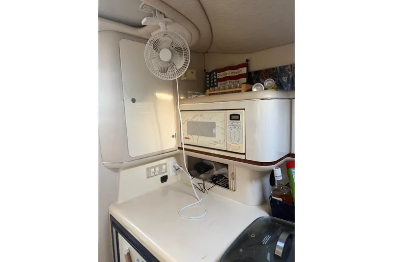 Slide: The Image of 1996 Sea Ray Sundancer 330 interior with microwave, fan, and storage. - 18