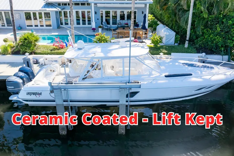 The Image of 2016 Intrepid 400 Cuddy boat, ceramic coated, lift kept, docked by a modern house. - 0