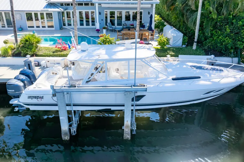 Slide: The Image of 2016 Intrepid 400 Cuddy boat docked near a luxurious waterfront home. - 100