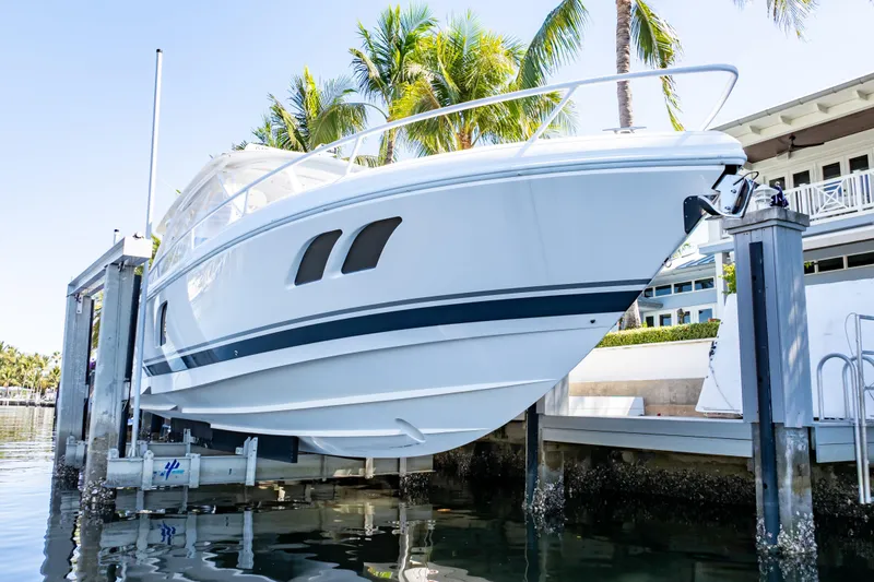 Slide: The Image of 2016 Intrepid 400 Cuddy boat docked near palm trees and waterfront home. - 101