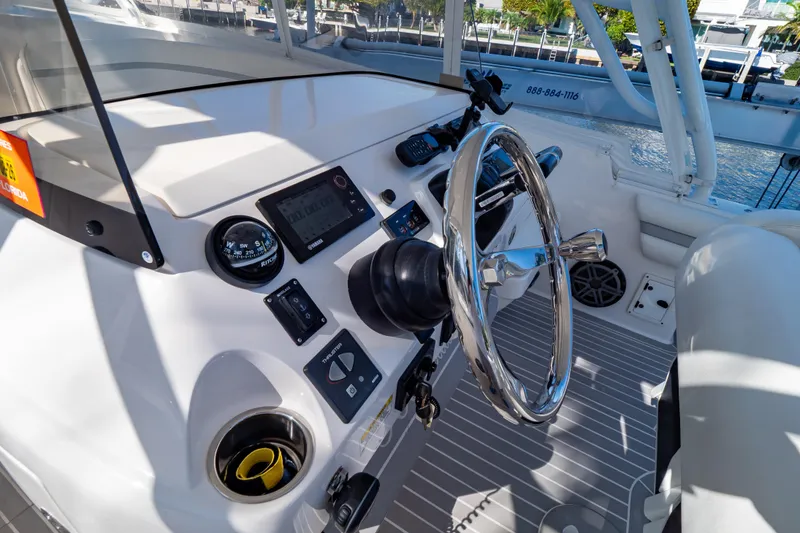 Slide: The Image of Intrepid 400 Cuddy 2016 helm with steering wheel, compass, and navigation controls. - 108