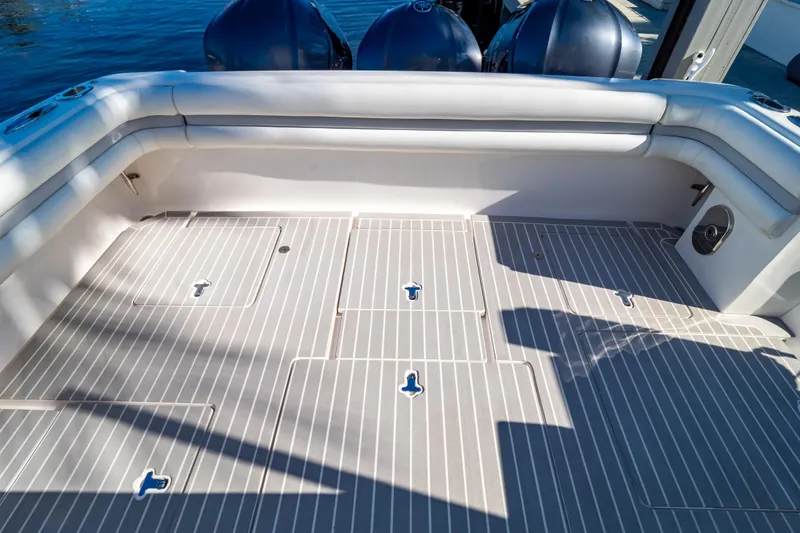 Slide: The Image of 2016 Intrepid 400 Cuddy boat deck with cushioned seating and storage compartments. - 115