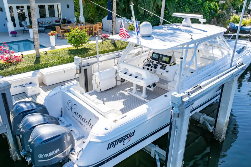 Slide: The Image of 2016 Intrepid 400 Cuddy boat docked, featuring Yamaha engines and a spacious cockpit. - 137