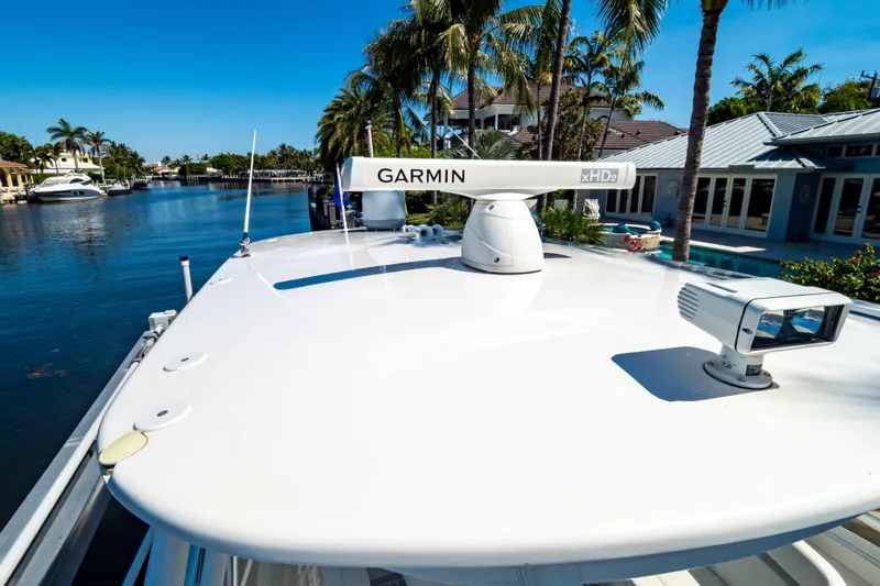 Slide: The Image of 2016 Intrepid 400 Cuddy boat with Garmin radar, docked by palm trees and waterfront homes. - 14