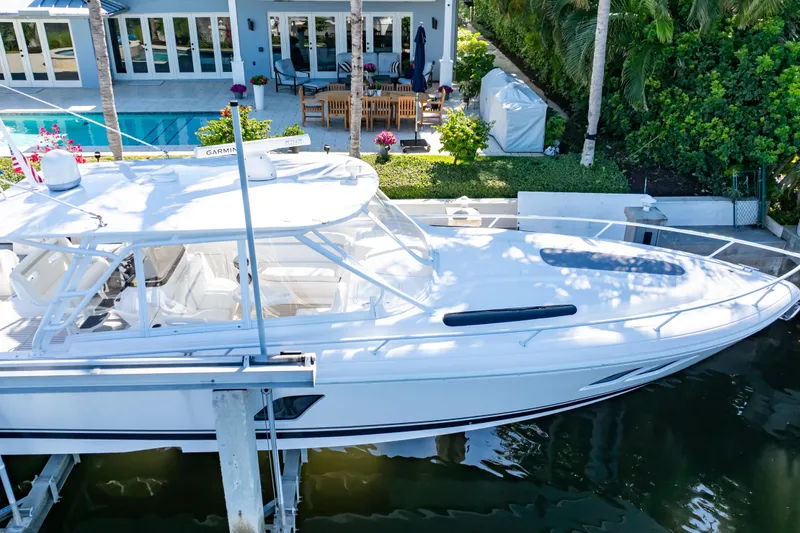 Slide: The Image of 2016 Intrepid 400 Cuddy docked near a luxurious waterfront home. - 140