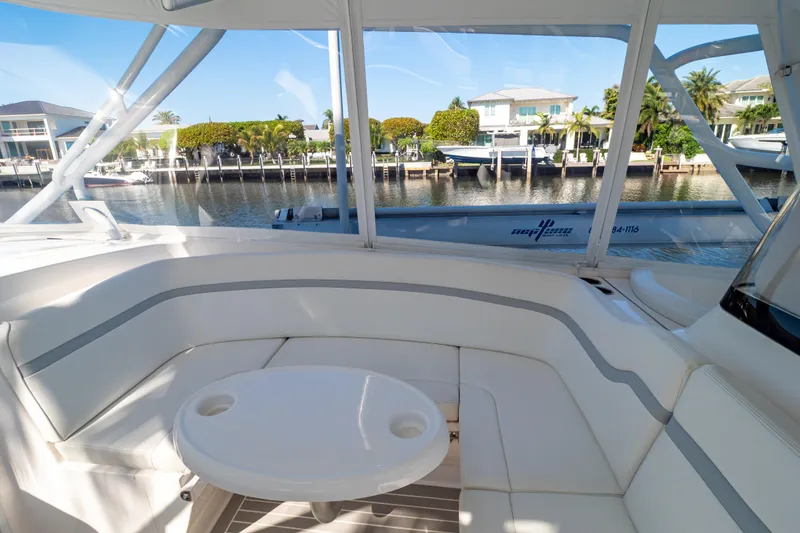 Slide: The Image of Luxurious seating area on a 2016 Intrepid 400 Cuddy yacht, docked by waterfront homes. - 15