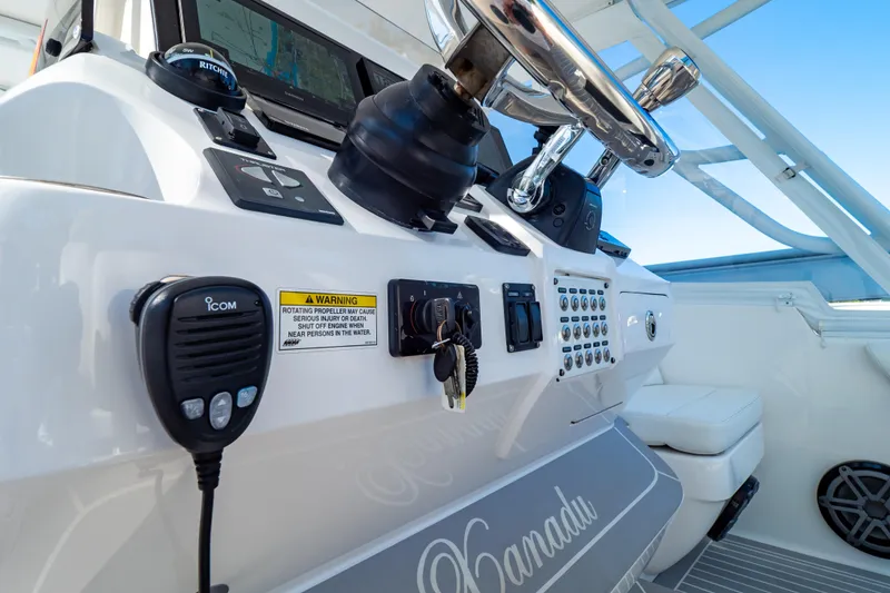 Slide: The Image of Control panel of a 2016 Intrepid 400 Cuddy boat with steering wheel and communication equipment. - 16