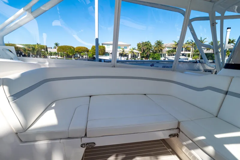 Slide: The Image of 2016 Intrepid 400 Cuddy boat interior with white seating and waterfront view. - 27