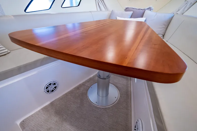 Slide: The Image of Interior of 2016 Intrepid 400 Cuddy featuring a wooden table and cushioned seating. - 29