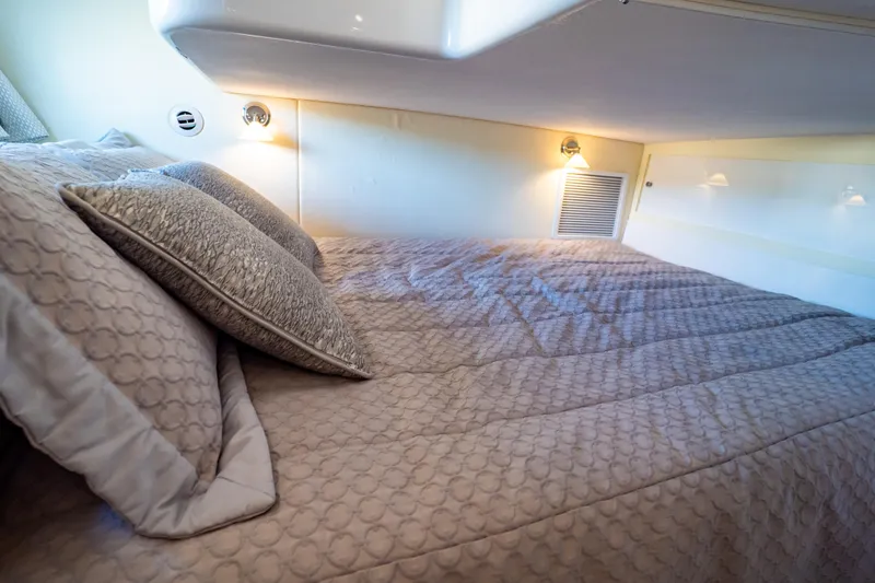 Slide: The Image of Cozy cabin interior of 2016 Intrepid 400 Cuddy with elegant bedding and soft lighting. - 30