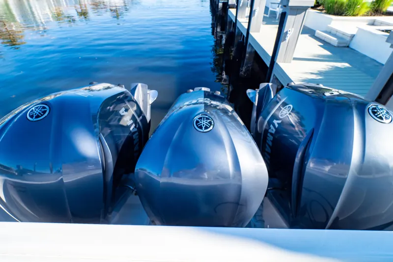 Slide: The Image of Triple Yamaha outboard engines on a 2016 Intrepid 400 Cuddy boat docked by the water. - 31