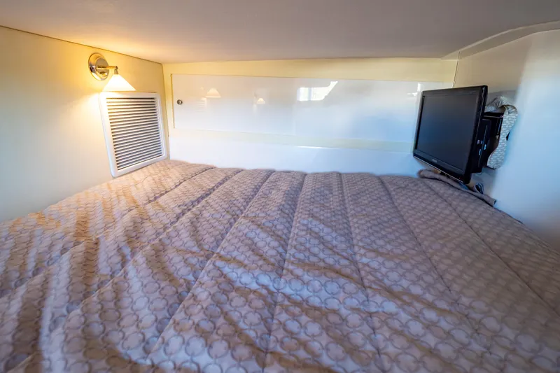 Slide: The Image of Cozy cabin interior of 2016 Intrepid 400 Cuddy with bed, TV, and wall light. - 36