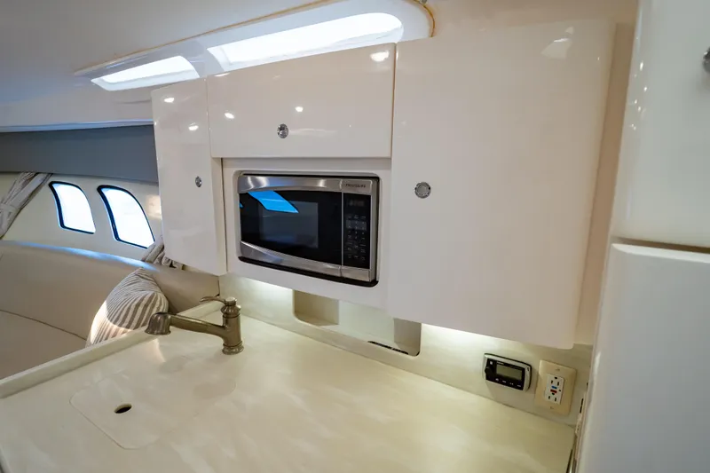 Slide: The Image of 2016 Intrepid 400 Cuddy interior with microwave, sink, and modern cabinetry. - 46